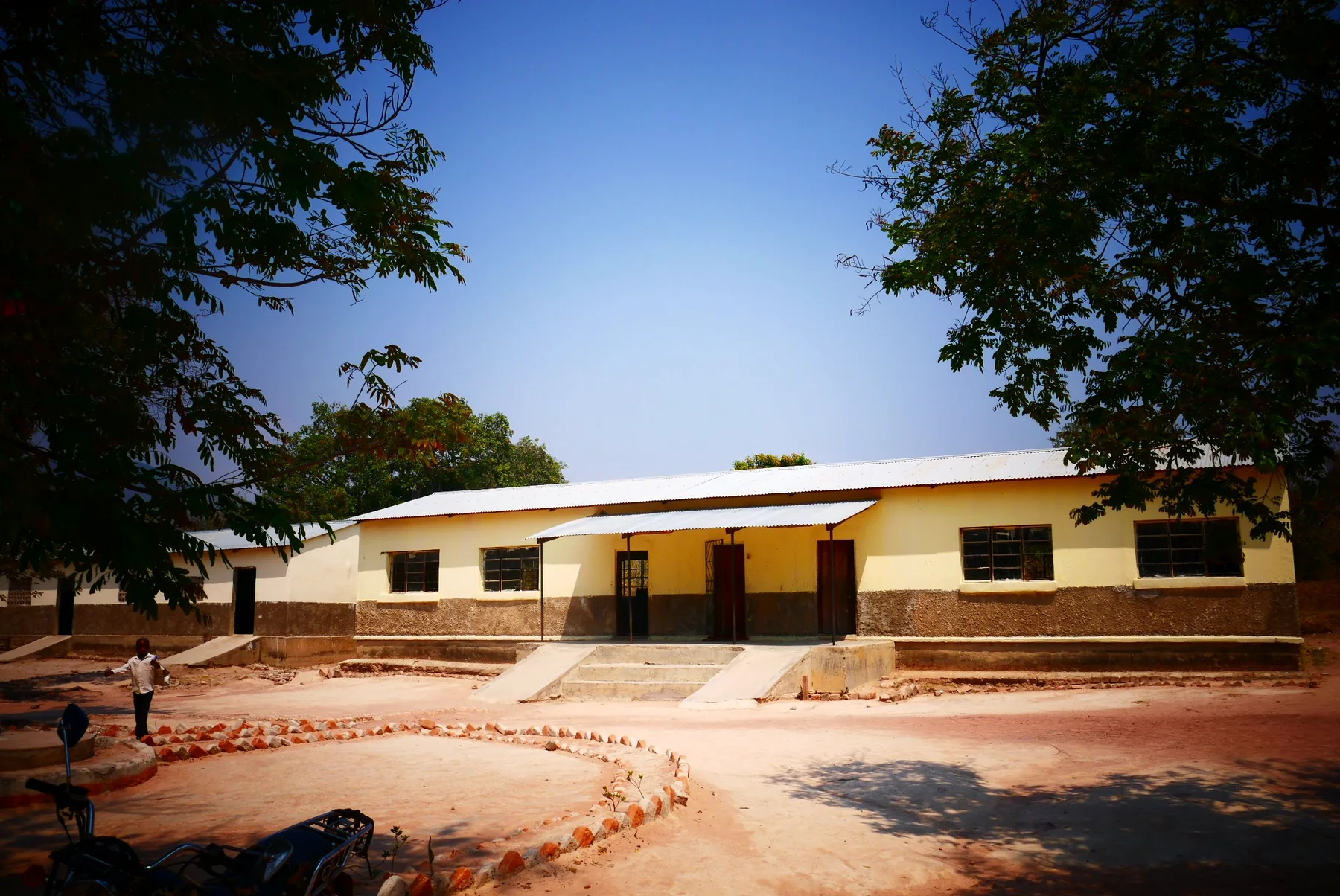 Exterior of Mwiniwise Combined School framed by trees