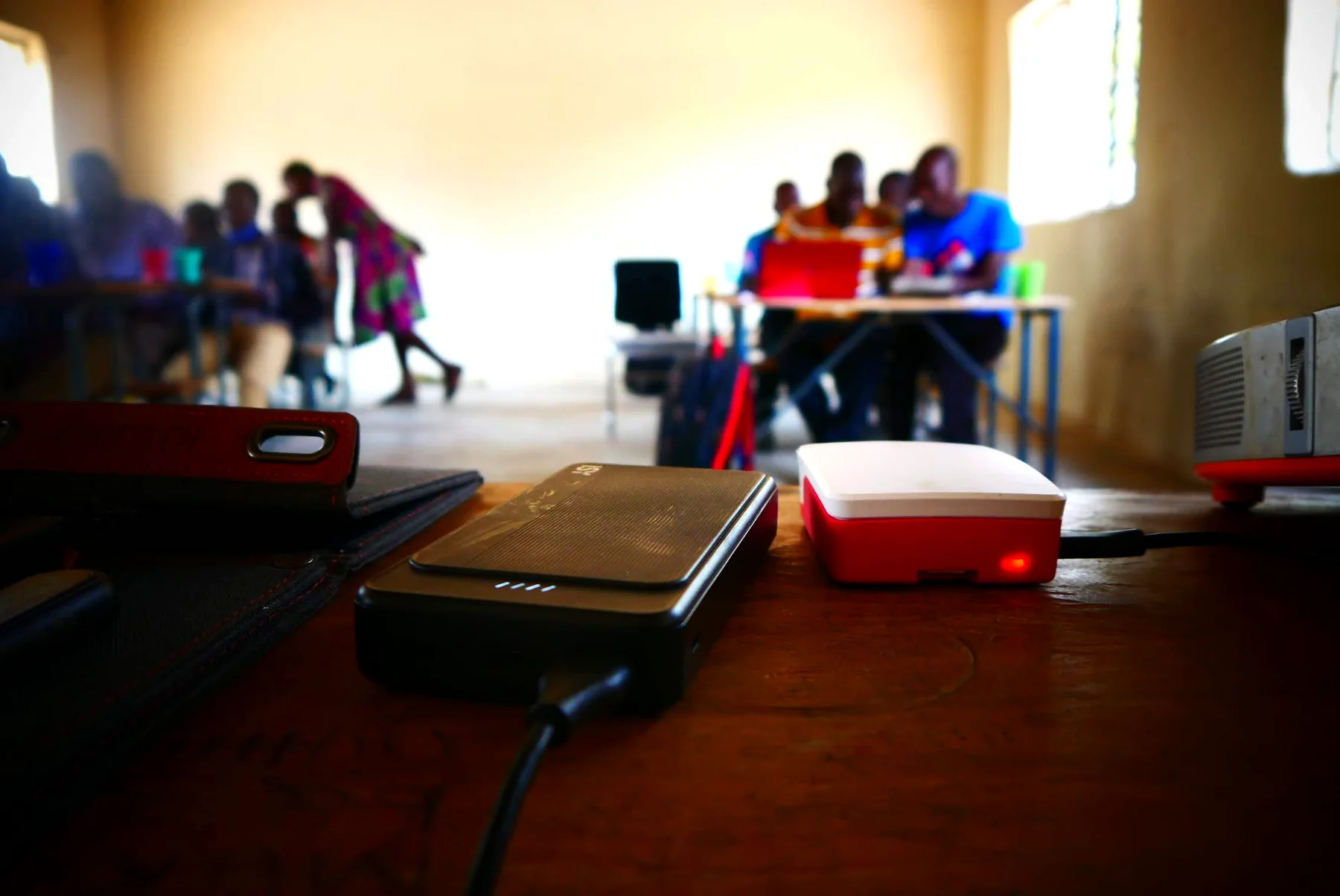 Portable power bank and Raspberry Pi offline learning server arranged on a classroom desk