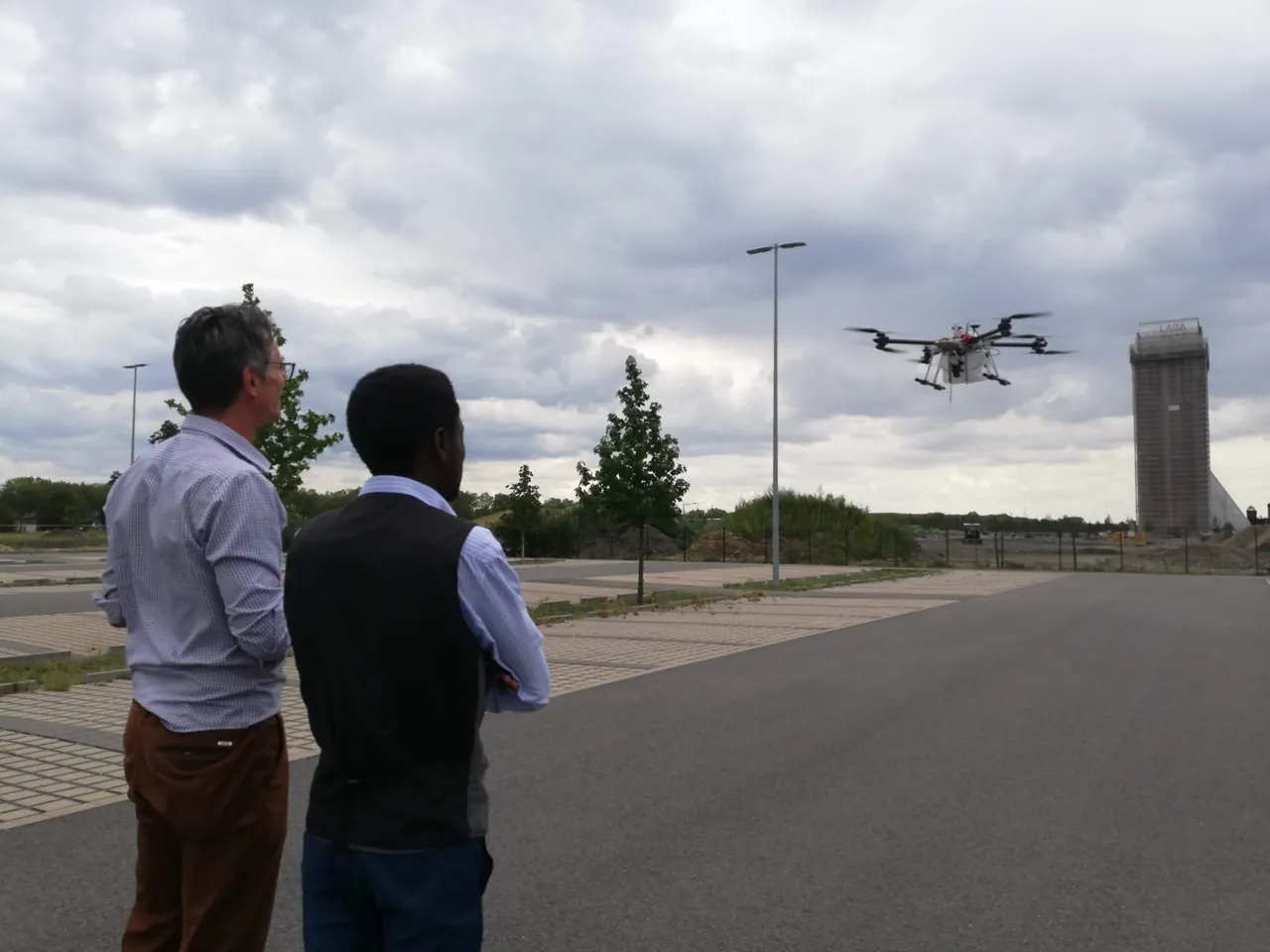 Two people watching a multirotor drone in flight during a SPECTORS demonstration in August 2019