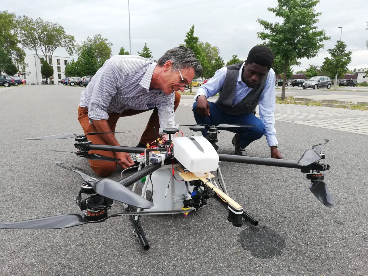 Two people examining a large multirotor drone on the ground during a SPECTORS demonstration in August 2019